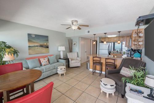 a living room and kitchen with a couch and a table at Island Winds West 875 by ALBVR - Upgraded Beachfront Condo - Fantastic Location in Gulf Shores