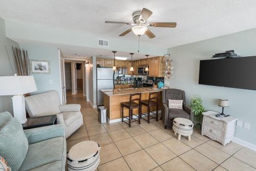 a living room with a couch and a kitchen at Island Winds West 875 by ALBVR - Upgraded Beachfront Condo - Fantastic Location in Gulf Shores
