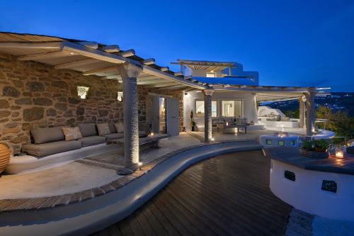 an outdoor patio with a couch and a table at Paraga Villa1 "7min WALK TO BEACH" by Calypso Sunset Villas in Mikonos