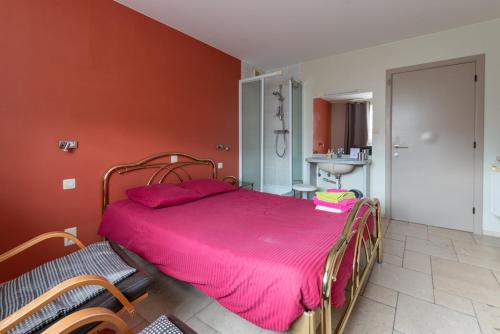 a bedroom with a large bed with a pink blanket at Logies Ternier in Nieuwpoort