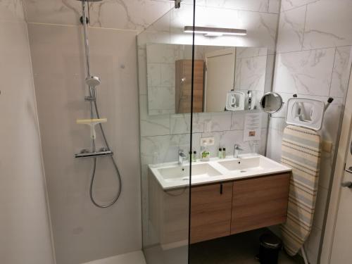 La salle de bains est pourvue d'une douche et d'un lavabo. dans l'établissement Laurina's Cove, à Ostende
