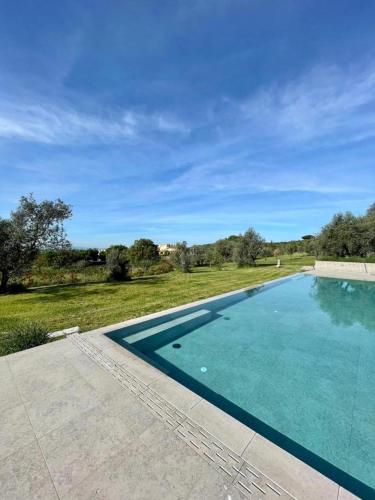 a large swimming pool in a yard with a field at Villa Paladini in Montefiascone