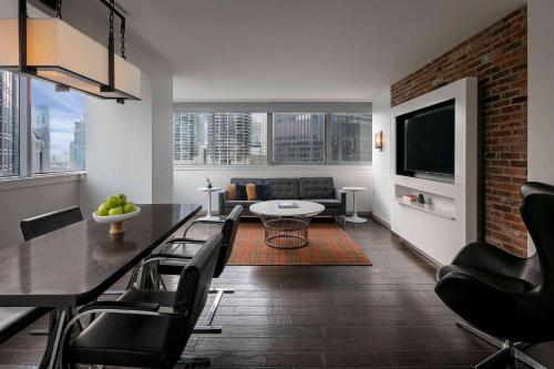a living room with a table and chairs and a television at The Royal Sonesta Chicago Downtown in Chicago