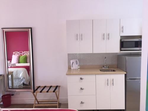 a kitchen with white cabinets and a mirror at Blue Lagoon Hotel and Marina Ltd in Kingstown