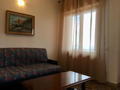 uma sala de estar com um sofá, uma mesa e uma janela em MareMonti em Massa