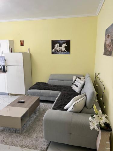 a living room with a couch and a refrigerator at PARADISE LUXURY APARTMENTS in Nea Kalikratia