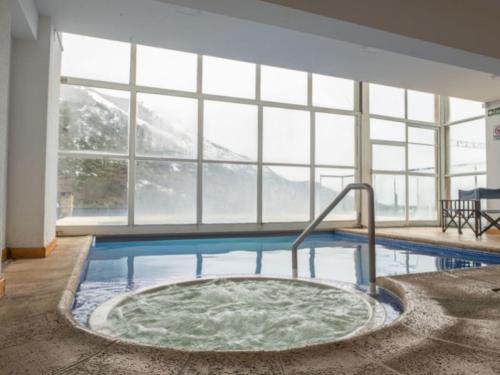 una gran piscina con bañera de hidromasaje en una habitación con ventanas en Hosteria del Cerro en San Carlos de Bariloche