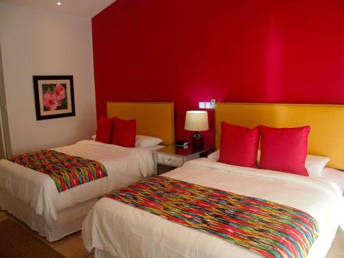 a hotel room with two beds with red walls at Blue Lagoon Hotel and Marina Ltd in Kingstown