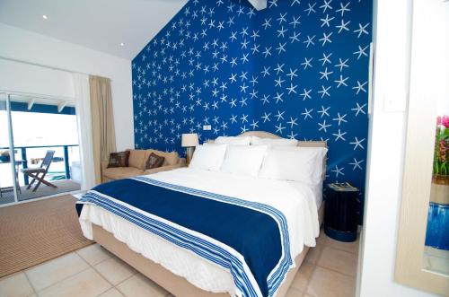 a bedroom with a blue wall with white stars at Blue Lagoon Hotel and Marina Ltd in Kingstown