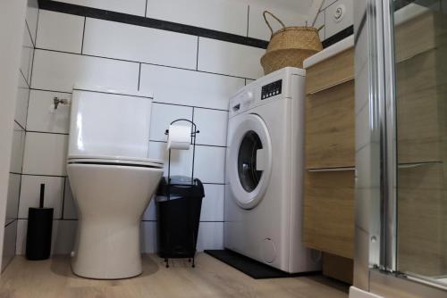 a bathroom with a toilet and a washing machine at Entre terre et Mer in Saint-Lormel