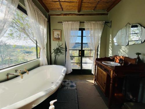 a large bathroom with a tub and a sink at 360on62 Farm Cottages in Montagu