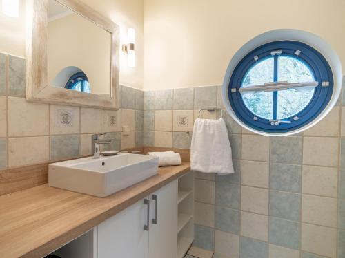 a bathroom with a sink and a window at Ferienhaussiedlung Strandperlen Sanddornhof 6b (Typ VII) in Wustrow