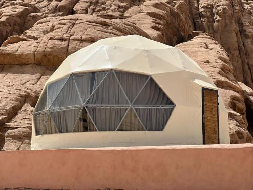 um edifício em forma de cúpula em frente a algumas rochas em Princess luxury camp em Wadi Rum