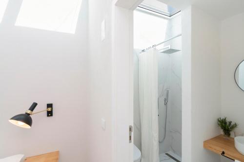 a white bathroom with a shower and a sink at Casa da Zanjas in Seia