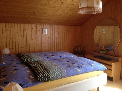 Schlafzimmer mit einem Bett mit blauer Decke in der Unterkunft Staldenried Ferienwohnung in Staldenried