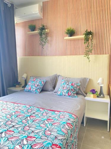 a bed in a bedroom with plants on the wall at Quarto Nº7 FAMILIA VEIGA - Central Praia in Praia