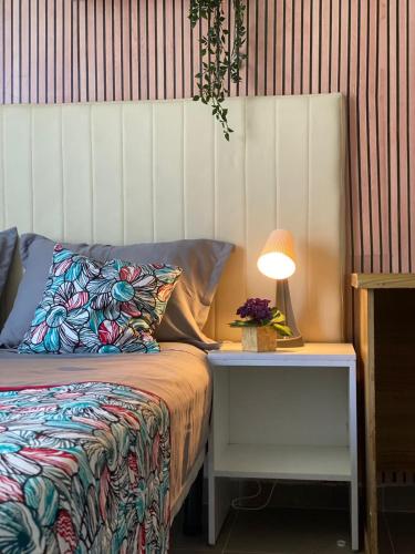 a bedroom with a bed and a table with a lamp at Quarto Nº7 FAMILIA VEIGA - Central Praia in Praia