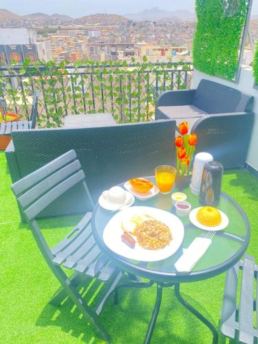 a table with a plate of food on a balcony at Quarto Nº7 FAMILIA VEIGA - Central Praia in Praia