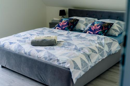 a bed with a blue and white quilt on it at Domek pod Nowiną in Tylmanowa