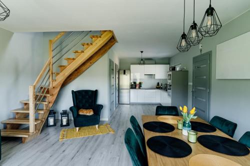 a living room with a dining room table and a staircase at Domek pod Nowiną in Tylmanowa