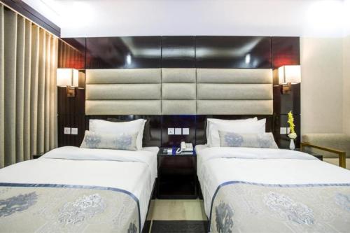 two beds in a hotel room with two beds sidx sidx sidx at White Palace Hotel in Dhaka