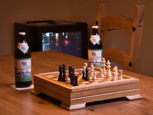 two bottles of beer sitting next to a chess board at Hotel Garni Landhaus Sonnenstern in Schönau am Königssee