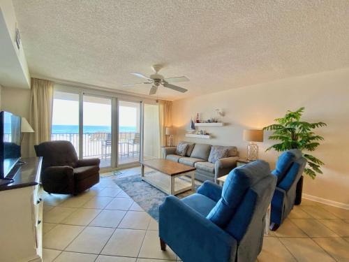 a living room with a couch and chairs and a television at Wind Drift 102S by ALBVR - 2BR, 2BA Beautiful Upgraded Beachfront Condo near Flora Bama, Outdoor Pools and Tennis Courts in Orange Beach