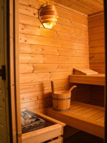 a wooden sauna with a bucket in it at Hotel Garni Landhaus Sonnenstern in Schönau am Königssee