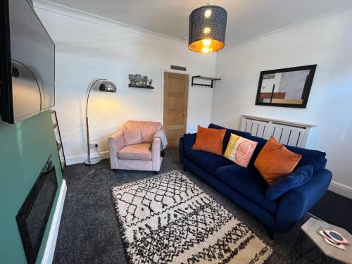 a living room with a blue couch and a chair at Hilton House in Barnsley