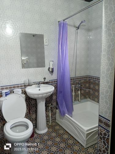 a bathroom with a toilet and a sink and a shower at Bohodir Guest House in Samarkand