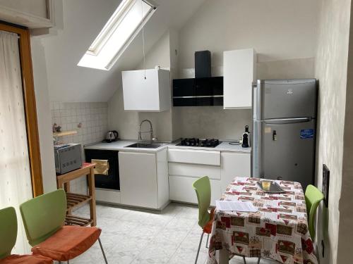 una cucina con frigorifero e tavolo con sedie di La casa di Giada a Peschiera Borromeo