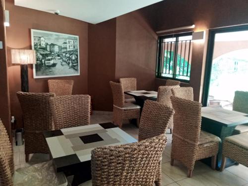 a dining room with chairs and tables and a window at Trois Ore Residences & Green Earth Bistro in Ibadan
