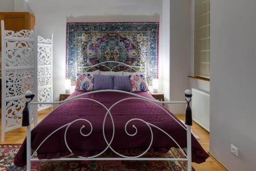 um quarto com uma cama com uma colcha roxa em Bohemian studio in the city centre em Budapeste