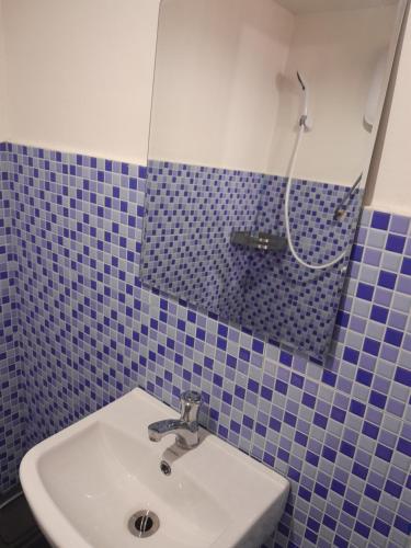 a blue tiled bathroom with a sink and a mirror at Jamilla's Private Pool Resort in Pinamalayan