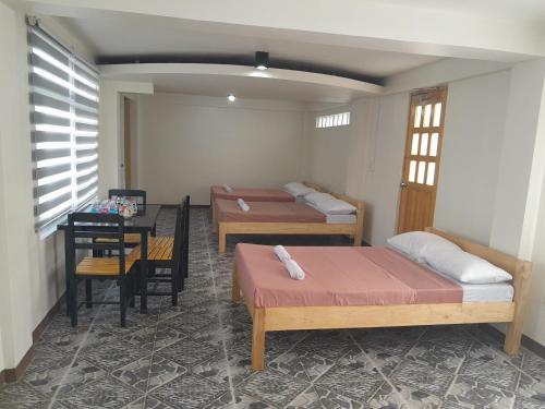 a room with two beds and a table with a tableablish at Jamilla's Private Pool Resort in Pinamalayan