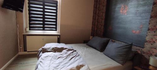 ein kleines Bett in einem Schlafzimmer mit Fenster in der Unterkunft Gästewohnung Cottbuser City in Cottbus