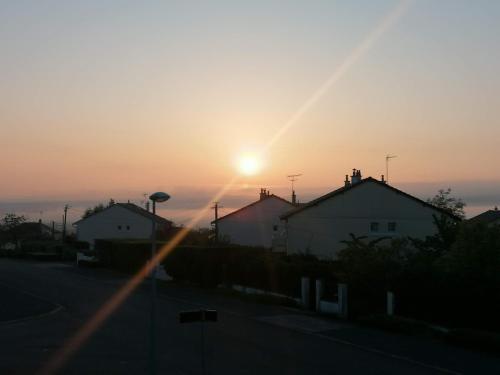 a sunset over a street with houses and a road at NOUVEAUTE Maison Cocooning avec jardin, Terrasse couverte et Jacuzzi in Bellerive-sur-Allier