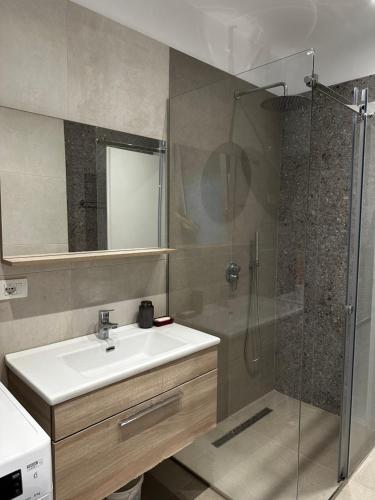 ein Bad mit einem Waschbecken und einer Dusche in der Unterkunft ByBreeze Appartments in Durrës