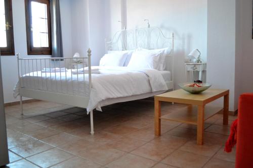 a bedroom with a white bed and a table at Aegean View House in Agios Ioannis Pelio