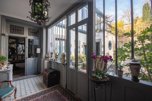 una habitación con grandes ventanas y una habitación con flores en Le Jardin Secret & Spa, en Saint-Brieuc