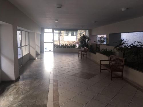 un couloir avec des chaises et des plantes dans un bâtiment dans l'établissement Apto climatizado -garagem, à Florianópolis