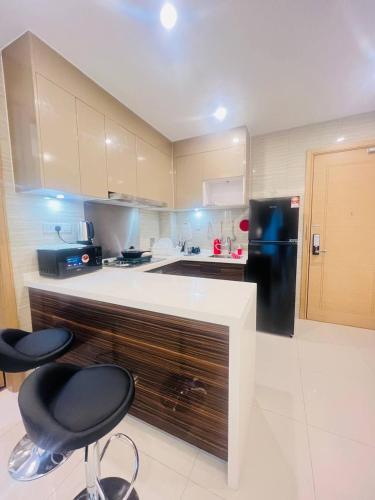 a kitchen with two chairs and a black refrigerator at R&F PRINCESS COVE at ANJU in Johor Bahru