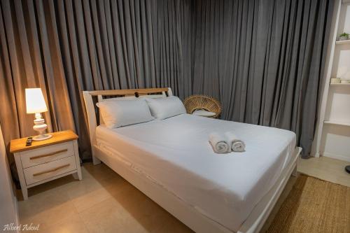 a bedroom with a bed with two slippers on it at דולב 55 מתחם סוויטות בוטיק Dolev 55 Boutique complex & Spa in Devora