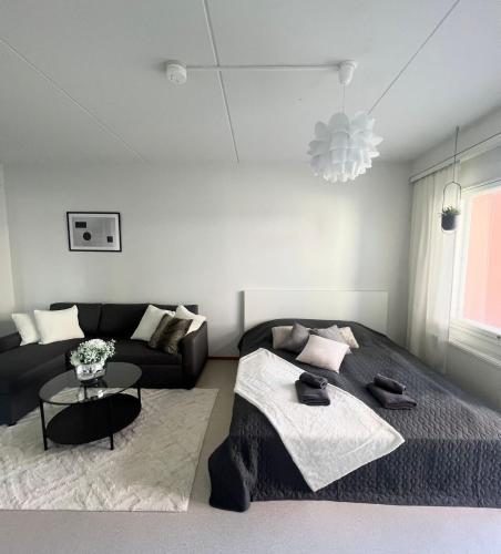 a living room with a bed and a couch at Annalan Helmi - Viihtyisä koti hyvillä kulkuyhteyksillä ja saunalla in Tampere