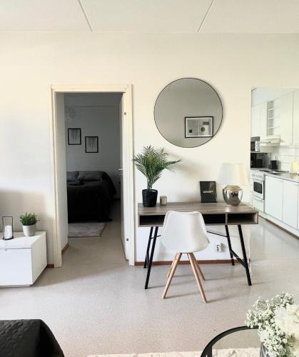 a living room with a table and a mirror at Annalan Helmi - Viihtyisä koti hyvillä kulkuyhteyksillä ja saunalla in Tampere