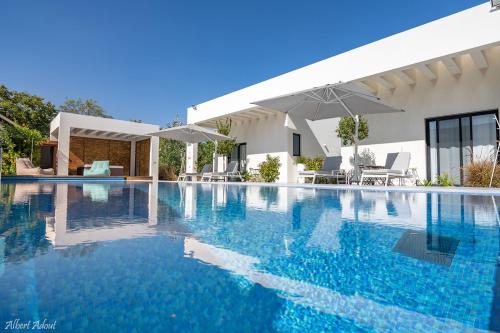 a swimming pool in front of a house at דולב 55 מתחם סוויטות בוטיק Dolev 55 Boutique complex & Spa in Devora