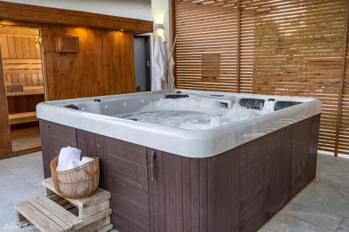 a jacuzzi tub in a room with a wooden wall at דולב 55 מתחם סוויטות בוטיק Dolev 55 Boutique complex & Spa in Devora