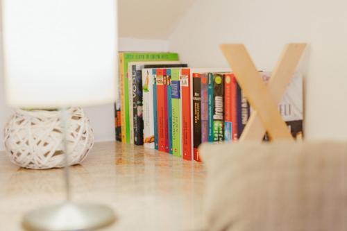 a lamp on a table next to a row of books at Apartma Pirano in Piran