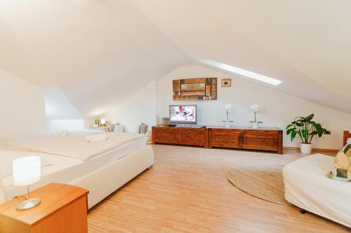 Habitación blanca grande con 2 camas y TV de pantalla plana. en Apartma Pirano en Piran