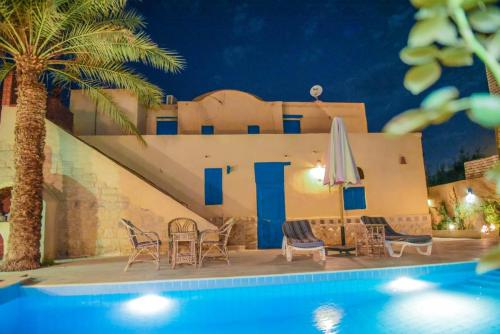 a villa with a swimming pool at night at فيلا بيجو in Tunis